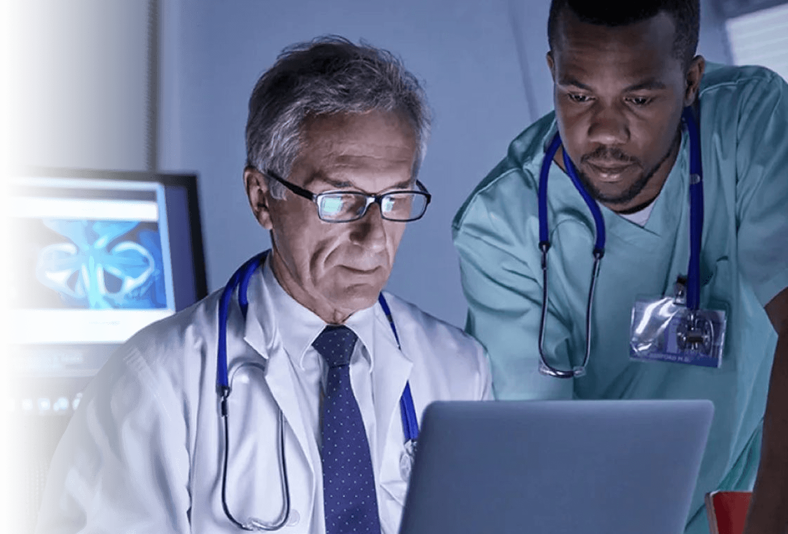Two clinicians reviewing a study together on a laptop